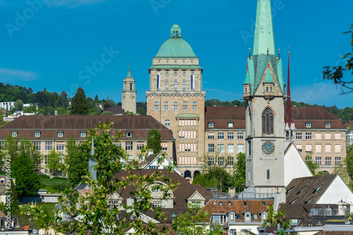 View of the historic center of Zurich at the bank of Limmat River  with beautiful house rooftops and University Zurich and church of Predigerkirche  view form Lindenhof hill.