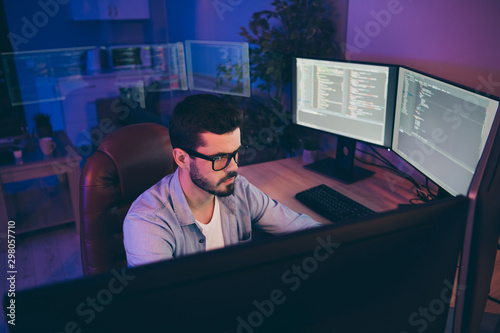 Photo of it specialist guy sitting comfy chair looking many monitors testing website algorithms serious content development expert dark night office indoors
