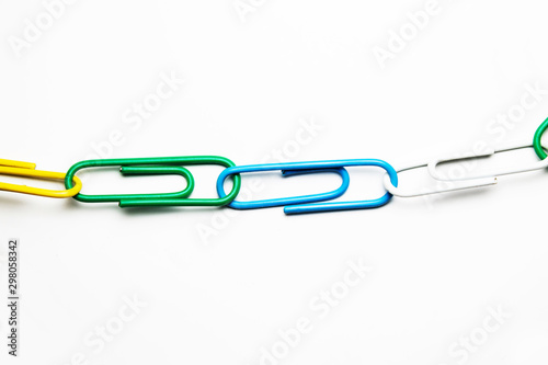 multicolored paper clips on a white background close-up