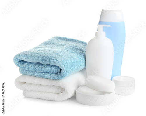 Folded soft towels and toiletries on white background photo
