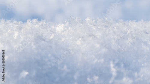 Background of fresh snow. Natural winter background. Snow texture in blue tone