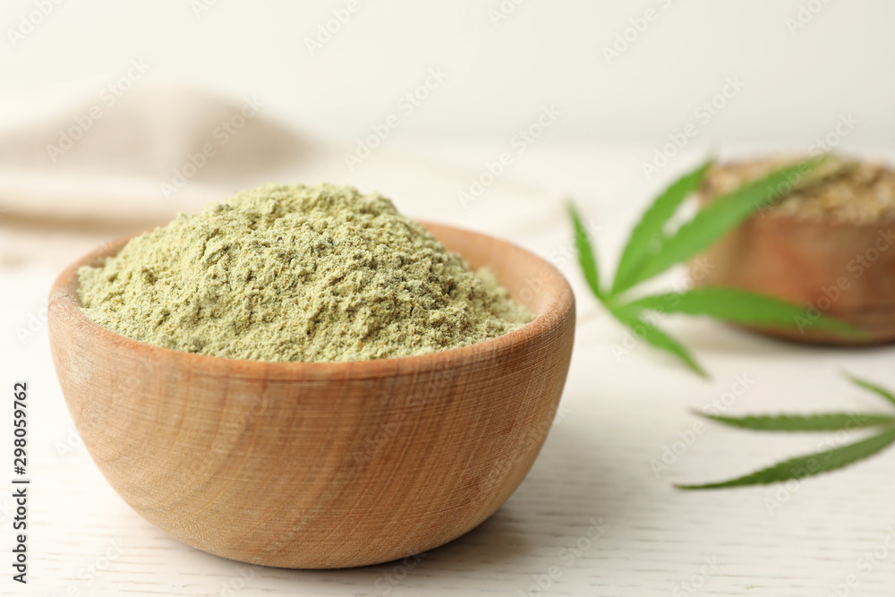 Bowl of hemp protein powder on white wooden table, closeup Bowl of hemp protein powder on white wooden table, closeup