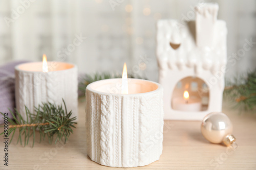 Composition with candle in ornate holder on wooden table. Christmas decoration