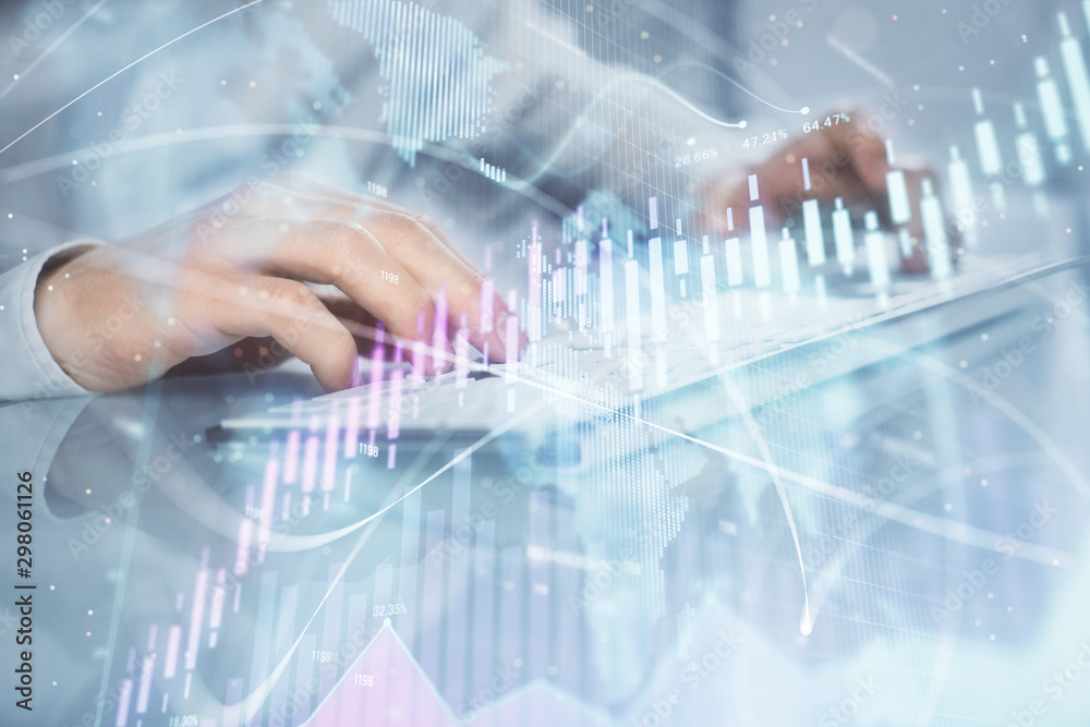 Double exposure of graph with man typing on computer in office on background. Concept of hard work. Closeup.