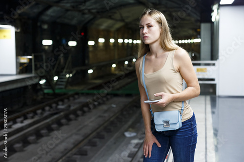 Girl using phone on subway station