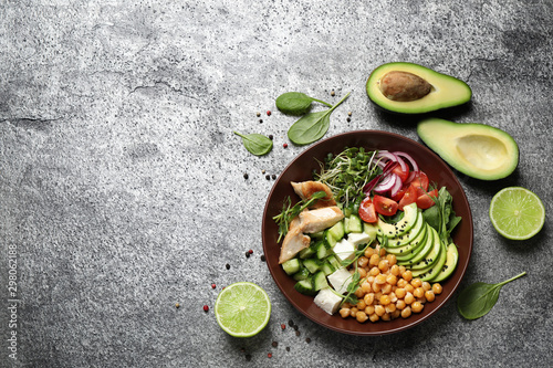 Delicious avocado salad with chickpea on grey table, flat lay. Space for text