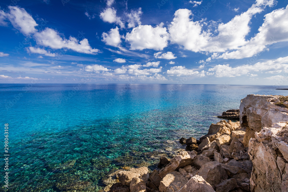 Sea coast with clear turquoise water and stones on cape Cavo Greco.