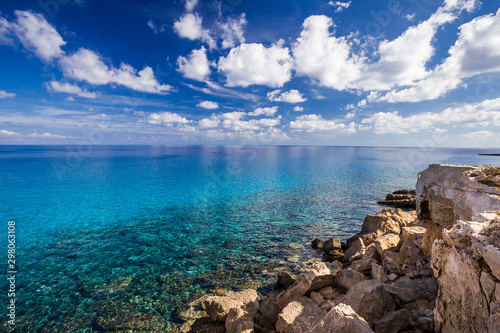 Sea coast with clear turquoise water and stones on cape Cavo Greco.