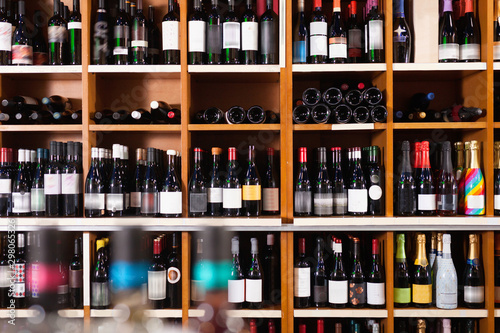 Konstfotografi Rows of wine bottles on shelves in modern wine store waiting for customers