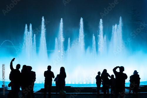 silhuette of people watching a water show in lima peru