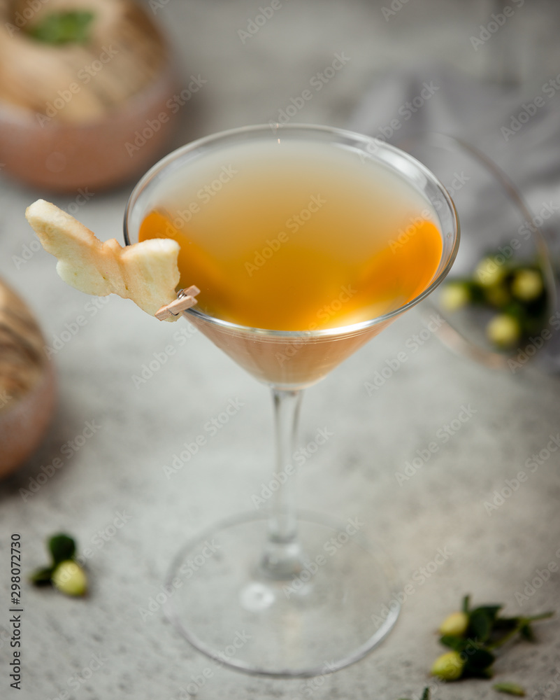 yellow color cocktail with apple slice
