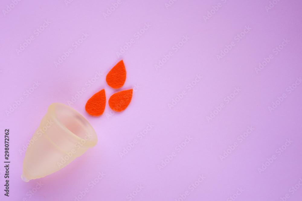 Menstrual cup with scarlet felt drops on pink background