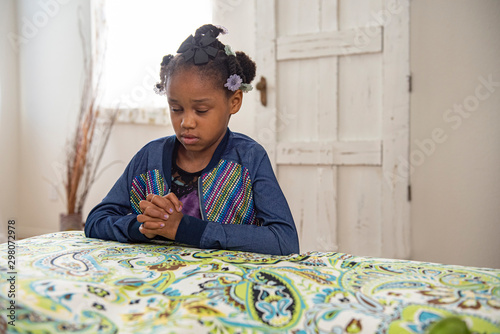 Wallpaper Mural African American girl prays by the side of her bed.  Torontodigital.ca