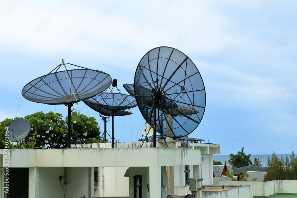 Satellite dish on the roof of hotel building near the sea in Thailand.