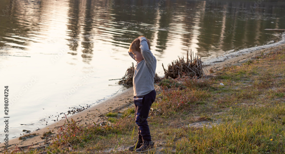 Little boy child grabbed his head on the beach because of bad water