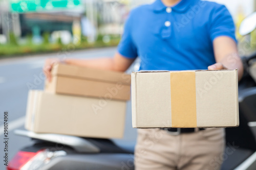 parcel delivery man and motorbike of a package through a service send to home. consign hand give submission customer accepting a delivery of boxes from delivery man. Transport by motorcycle  