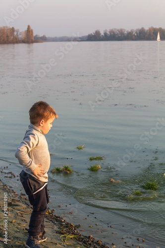 Little boy child angry, nervous, annoyed on the beach near the lake