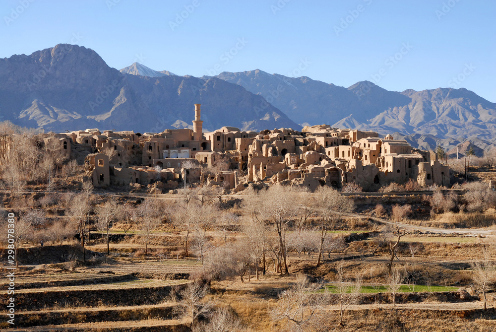 Terrace fields and ruins of medieval adobe mud-brick Kharanaq town. Iran.