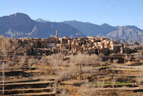Terrace fields and ruins of medieval adobe mud-brick Kharanaq town. Iran.