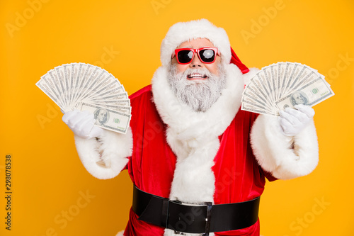 Credit bank x-mas lottery win. Funny funky white bearded santa claus hold double money jackpot fan become north-pole millionaire wear red hat headwear isolated over yellow color background photo