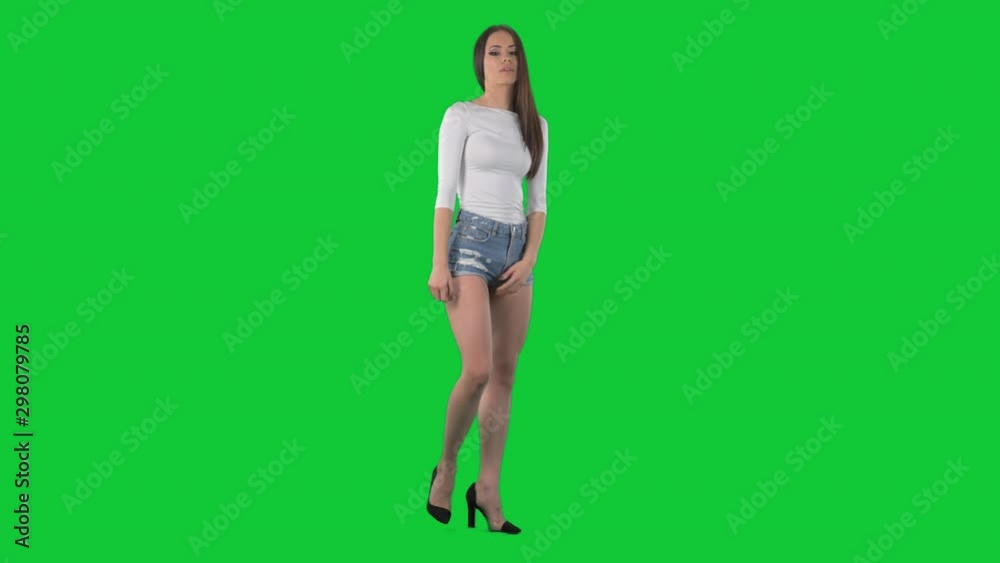 Young displeased woman pointing finger at camera blaming and accusing. Full body isolated on green screen chroma key background Young displeased woman pointing finger at camera blaming and accusing. Full body isolated on green screen chroma key background