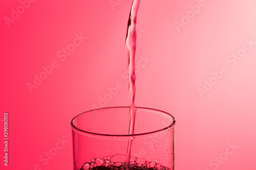 LLenando un vaso de agua, chorro de agua que se introduce en el interior de un vaso photo