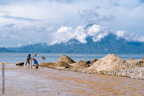 Dos personas est  n trabajando en el r  o que se junta con el lago Atitl  n Guatemala.