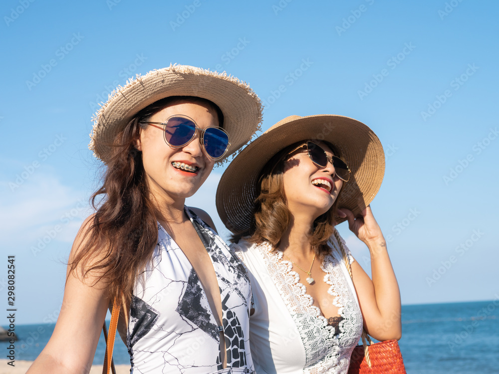 Happy Asian woman enjoying on the beach with straw hat in sunny day, lifestyle concept.