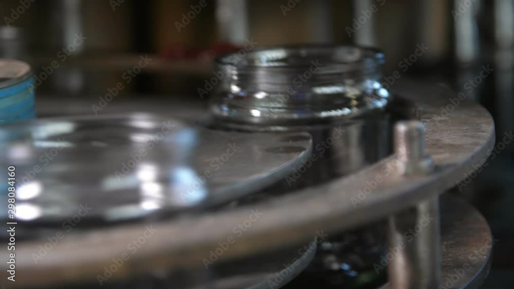 Hollow glass banks rotating on a conveyor stripe in a tomato processing plant Hollow glass banks rotating on a conveyor stripe in a tomato processing plant