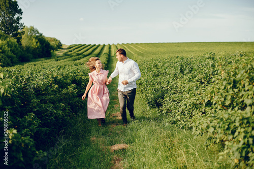 Couple in a field. Girl in a pink dress. Man in a white shirt © hetmanstock2