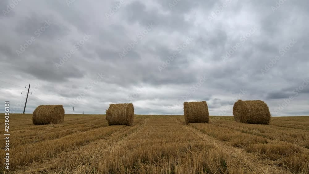 Yellow haystacks in the field wheat and cloudy sky. Beautiful scenic dynamic landscape agricultural land, 4K time lapse. Beauty nature, agriculture, harvest. Yellow haystacks in the field wheat and cloudy sky. Beautiful scenic dynamic landscape agricultural land, 4K time lapse. Beauty nature, agriculture, harvest.
