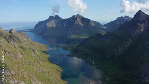 Drone shot of Lofoten steep cliffs and mountains rising from deep blue sea photo