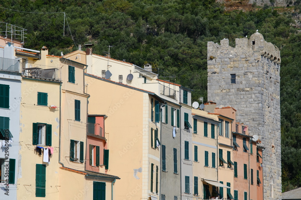 Typical Ligurian houses in the village of Portovenere. In the background a tower belonging to the walls of the fort. Typical Ligurian houses in the village of Portovenere. In the background a tower belonging to the walls of the fort.