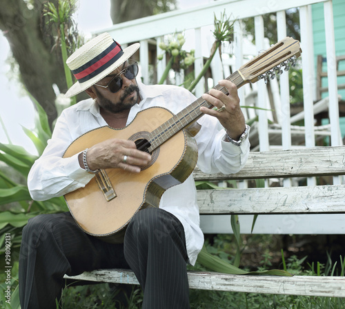 Photography A man playing a folk song in the cuban tres; a traditional guitar from Cuba