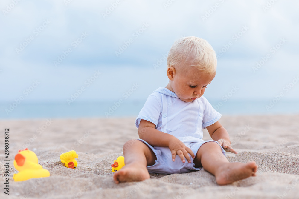 Portrait of baby boy playing with rubber ducks on the beach Portrait of baby boy playing with rubber ducks on the beach