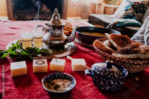Set of traditional Arab dessert and tray with teapot and cups placed on table during traditional tea ceremony