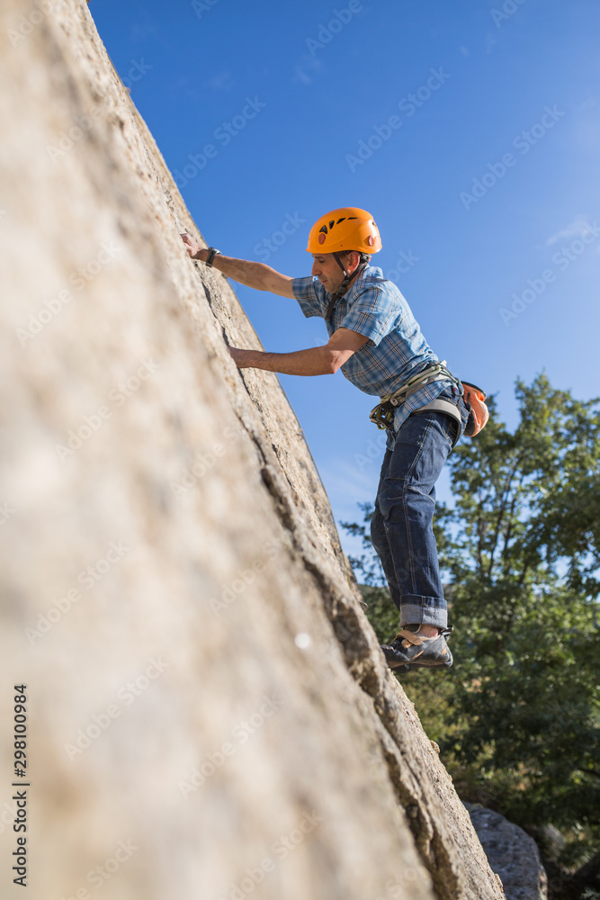 From below of free climber climbing in nature From below of free climber climbing in nature