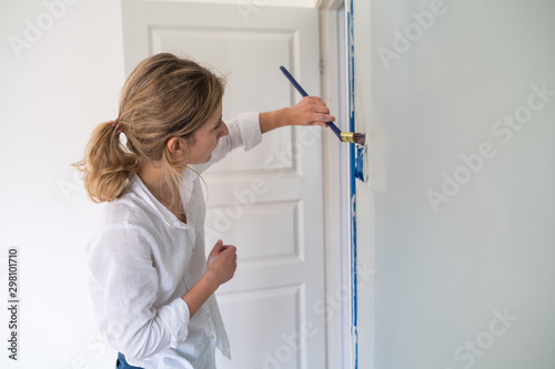 Woman painting around light switch