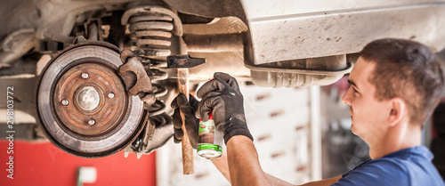 Car master mechanic repairer lubricates screws with machine cleaner spray photo