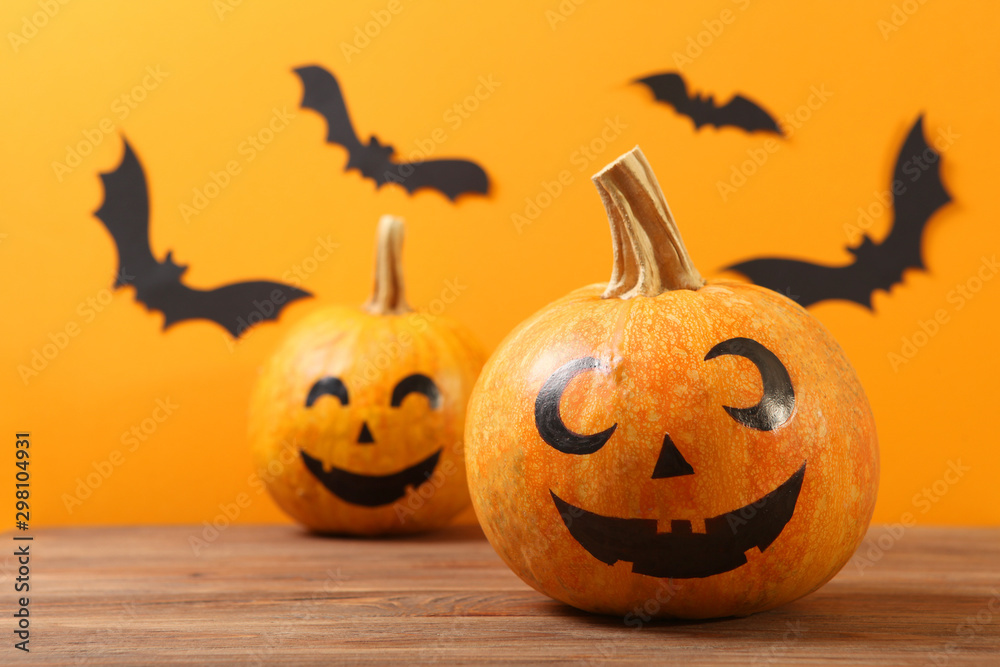 pumpkins with painted faces on a colored background for Halloween.