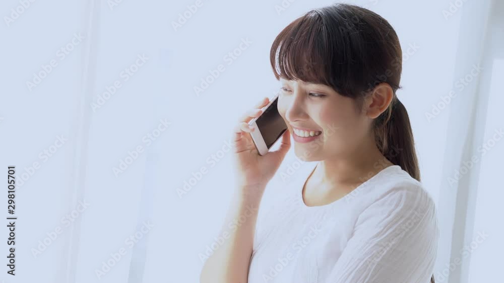 Beautiful young asian woman smiling standing relax in the bedroom, girl using mobile smart phone talking enjoy and fun, communication and social network concept. Beautiful young asian woman smiling standing relax in the bedroom, girl using mobile smart phone talking enjoy and fun, communication and social network concept.