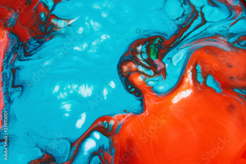 Vibrant red and blue paints mixing
