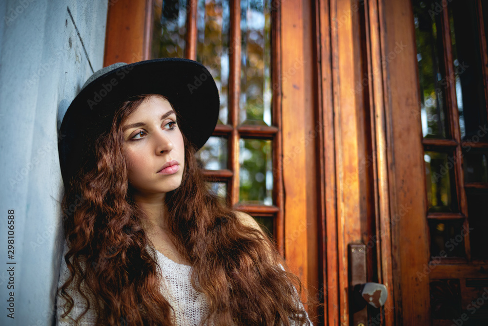 Sad and depressed young girl standing in front of door Sad and depressed young girl standing in front of door