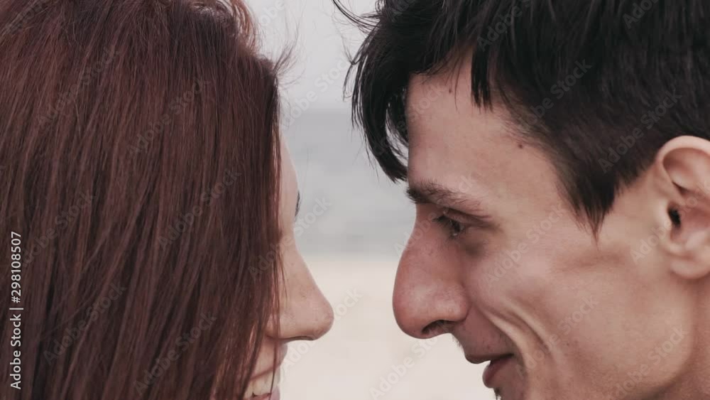 couple in love on the beach looking into each other eyes hugging at sunset romantic couple in love on the beach looking into each other eyes hugging at sunset romantic