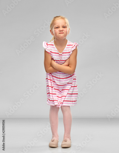 Canvas Print childhood and people concept - displeased little girl in red shirt with crossed