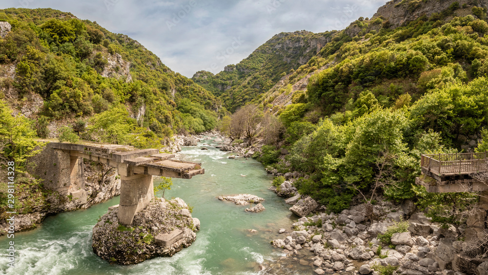 Broken bridge over fast running green river in the Tzoumerka region in Greece