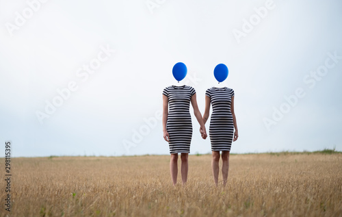 Two Women heads replaced by blue balloons