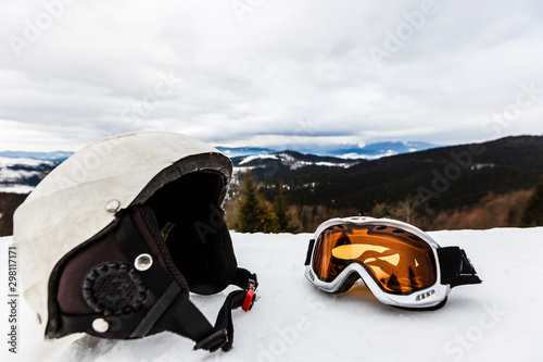 Ski helmet and ski goggles lie in the snow