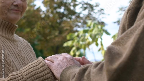 Senior man tenderly taking and hugging hands of mature wife, love and respect
