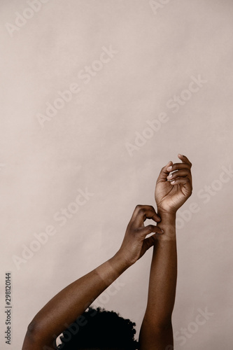 Anonymous black person scratching wrist photo